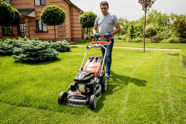 Gärtner mäht den Rasen. Landschaftsplanung. Grüner Hintergrund — Stockfoto