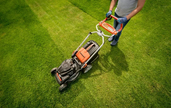 庭師は芝生を刈る。ランドスケープデザイン。緑の草の背景 ストック写真