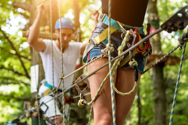 Junges Paar vergnügt sich im Abenteuer-Seilpark. — Stockfoto