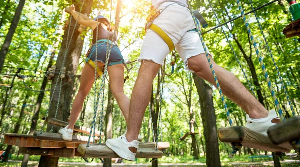 Jovem casal se divertindo no parque de corda de aventura. — Fotografia de Stock