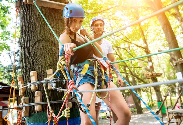 Junges Paar vergnügt sich im Abenteuer-Seilpark. — Stockfoto