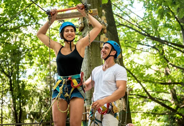 Young couple having fun time in adventure rope park.
