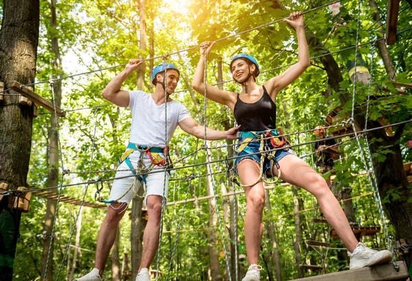 Junges Paar vergnügt sich im Abenteuer-Seilpark. — Stockfoto