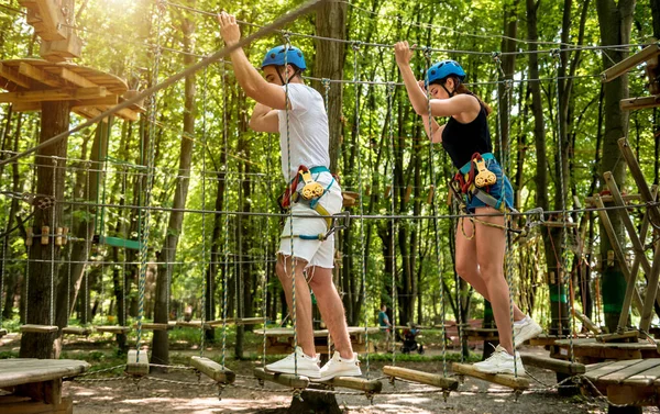 Junges Paar vergnügt sich im Abenteuer-Seilpark. — Stockfoto