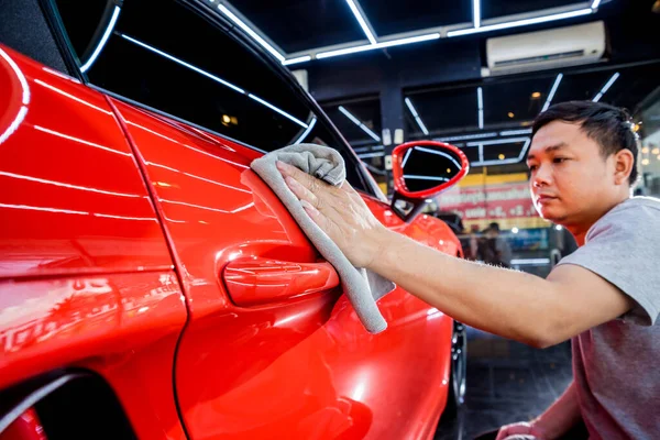 Auto service werknemer polijsten auto met microvezel doek. — Stockfoto