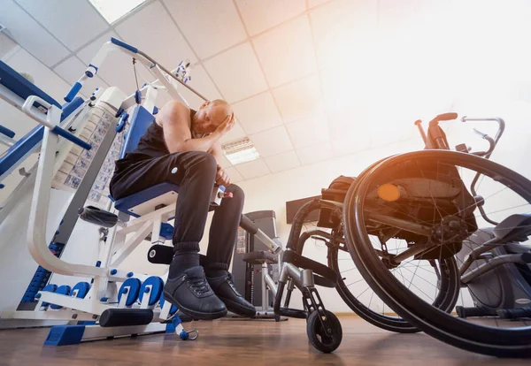 Tekerlekli sandalyeden ayrı olarak egzersiz yapan engelli bir adam.. — Stok fotoğraf