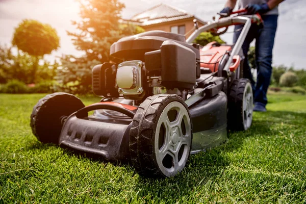 Jardinero cortando el césped. Diseño de paisaje. Fondo de hierba verde — Foto de Stock