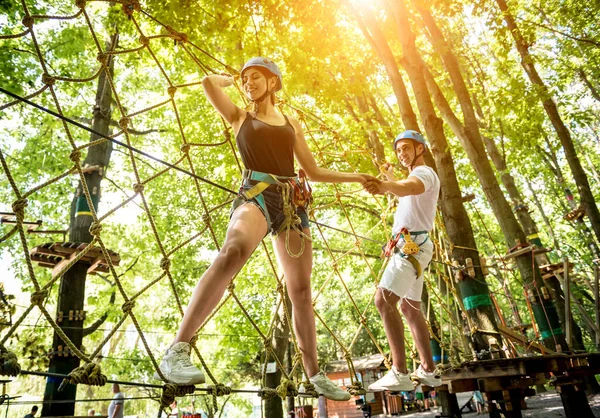 Junges Paar vergnügt sich im Abenteuer-Seilpark. — Stockfoto