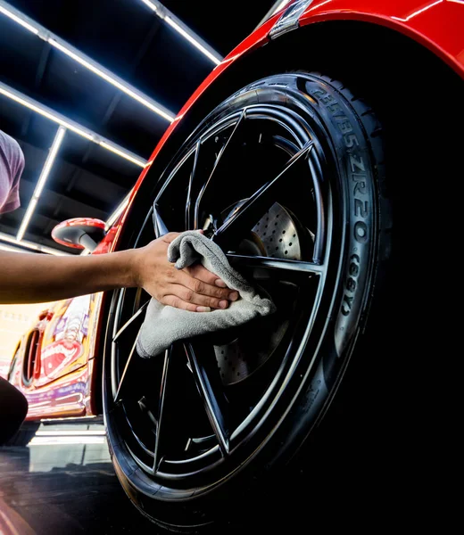 Trabajador de servicio de coche puliendo ruedas de coche con tela de microfibra. —  Fotos de Stock