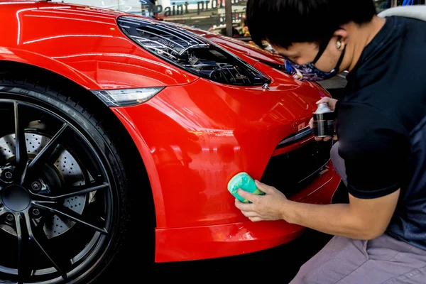 Trabajador de servicio de coches aplicando nano recubrimiento en un detalle del coche —  Fotos de Stock