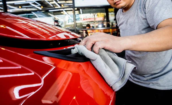 Auto service werknemer polijsten auto met microvezel doek. — Stockfoto