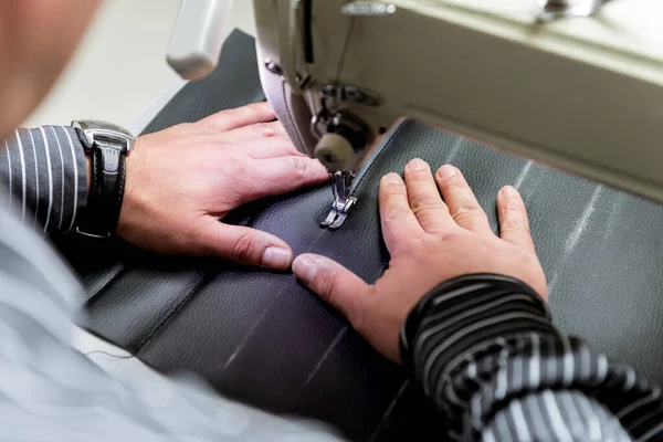 Designer tailleur coudre les housses de siège. L'homme utilise une machine à coudre pour son travail. — Photo