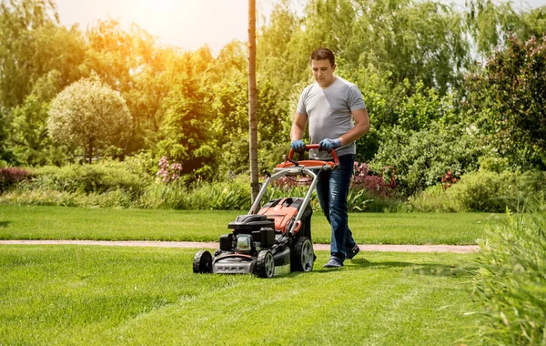 Jardinero cortando el césped. Diseño de paisaje. Fondo verde — Foto de Stock