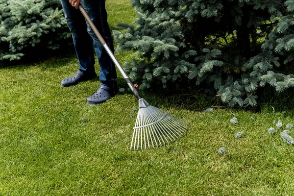 Gärtner harkt Laub im Garten. — Stockfoto