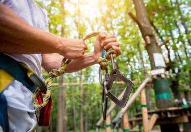 Macera halat parkında genç bir adam. Tırmanma Ekipmanı.