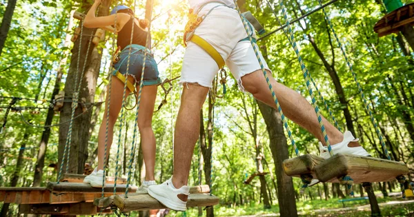 Pareja joven divirtiéndose en el parque de cuerdas de aventura. — Foto de Stock