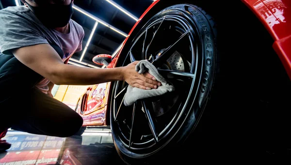 Autoservice-Mitarbeiter poliert Autoräder mit Mikrofasertuch. — Stockfoto