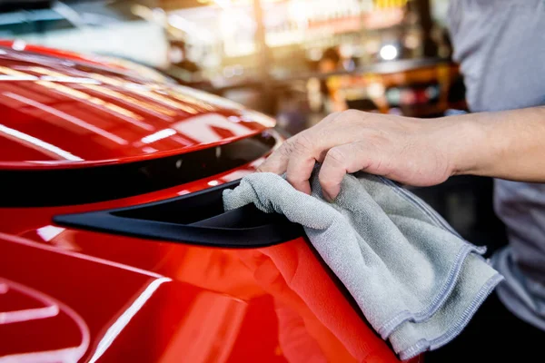 Auto service werknemer polijsten auto met microvezel doek. — Stockfoto