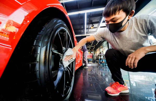 Bilservice arbetare polering bil hjul med microfiber duk. — Stockfoto