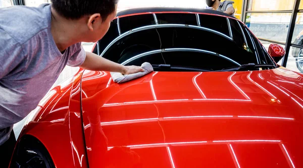 Auto service werknemer polijsten auto met microvezel doek. — Stockfoto