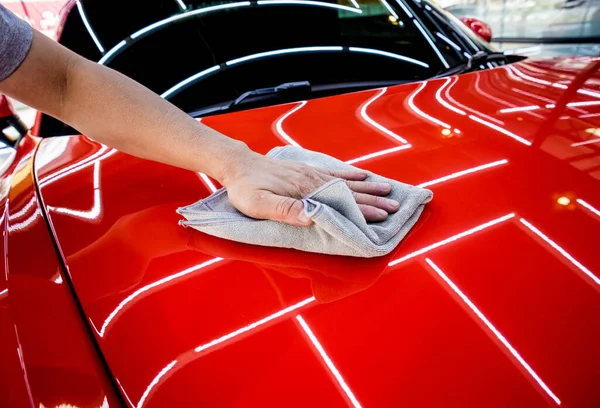 Serwis samochodowy pracownik polerowanie samochodu z mikrofibry tkaniny. — Zdjęcie stockowe