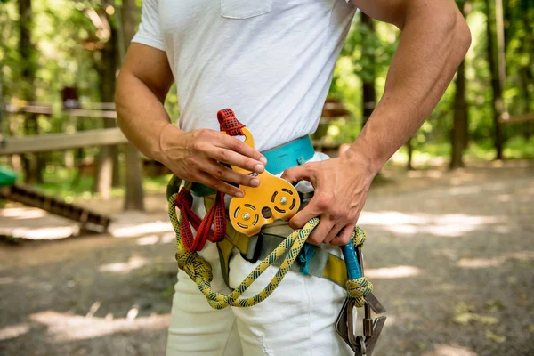 Junger Mann im Abenteuer-Seilpark. Kletterausrüstung. — Stockfoto