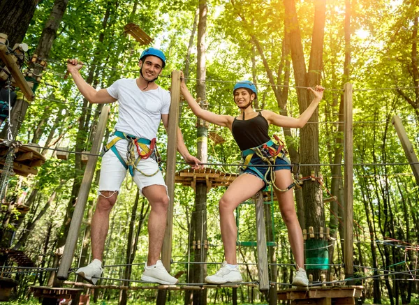 Junges Paar vergnügt sich im Abenteuer-Seilpark. — Stockfoto