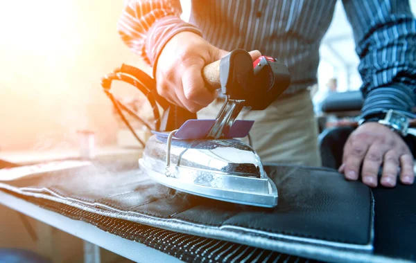 Design kleermaker naait stoelhoezen. De mens gebruikt ijzer voor zijn werk.. — Stockfoto