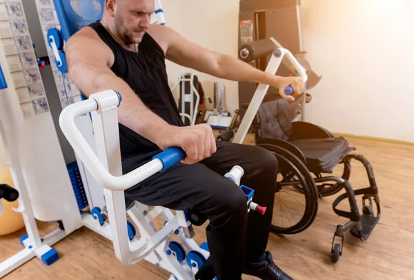 Tekerlekli sandalyeden ayrı olarak egzersiz yapan engelli bir adam.. — Stok fotoğraf