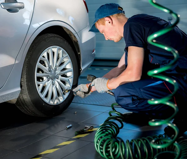 Mecánico de coche profesional que trabaja con en el servicio de reparación de automóviles. Reparación de ruedas — Foto de Stock