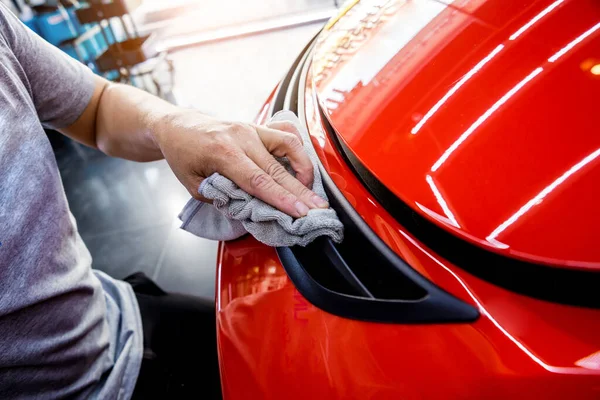 Auto service werknemer polijsten auto met microvezel doek. — Stockfoto