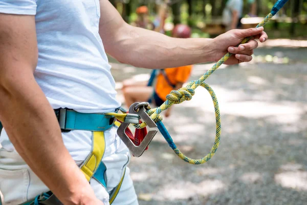 Junger Mann im Abenteuer-Seilpark. Kletterausrüstung. — Stockfoto