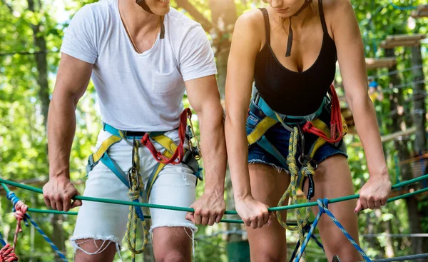 Junges Paar vergnügt sich im Abenteuer-Seilpark. — Stockfoto