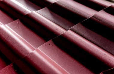 Kırmızı metalik çatı kiremitleri ve su damlaları.
