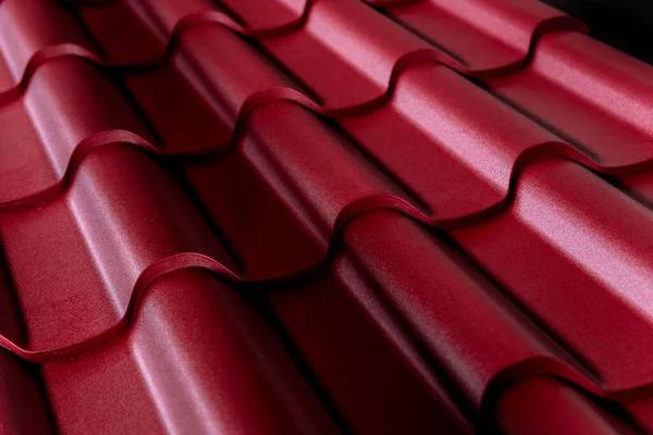 Red metallic roof tiles background with drops of water.