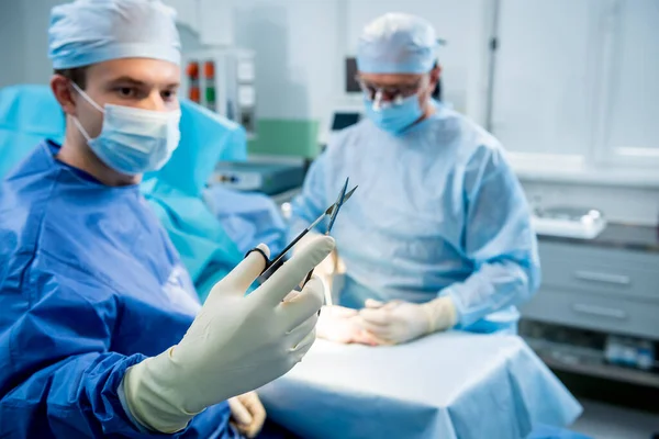 Surgeons in the operating room trying to save the patients hand. — Stock Photo, Image