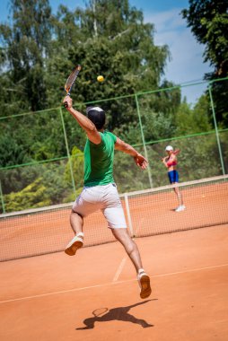 Sahada tenis oynayan genç atletik çift.