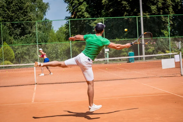 Młoda sportowa para grająca w tenisa na korcie. — Zdjęcie stockowe