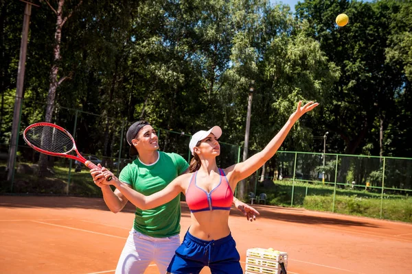 Junge athletische Frau spielt Tennis mit ihrem Trainer. — Stockfoto