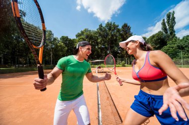 Sahada tenis oynayan genç atletik çift.