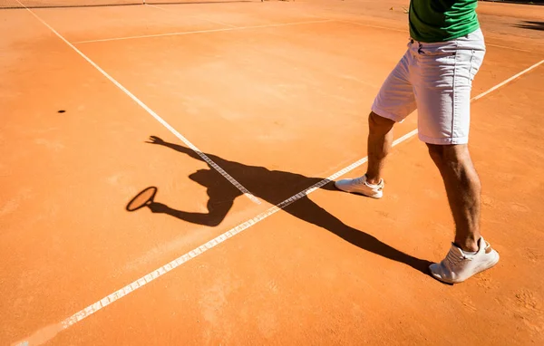 Sahada tenis oynayan genç bir atletik..