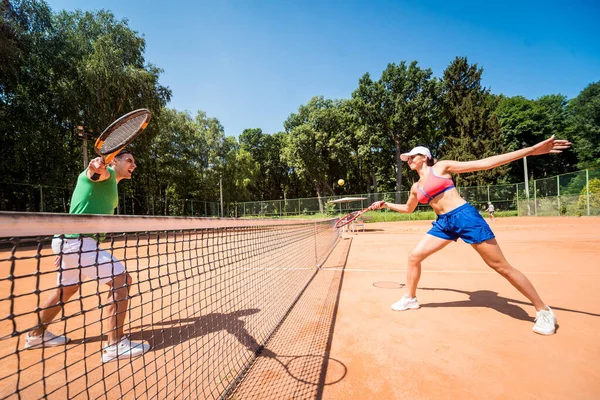 Młoda sportowa para grająca w tenisa na korcie. — Zdjęcie stockowe