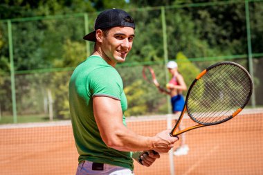 Sahada tenis oynayan genç atletik çift.