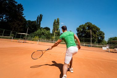 Sahada tenis oynayan genç bir atletik..