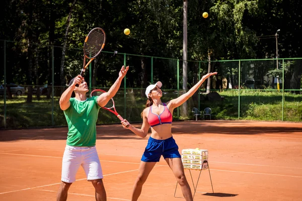 Молода спортсменка грає в теніс зі своїм тренером . — стокове фото