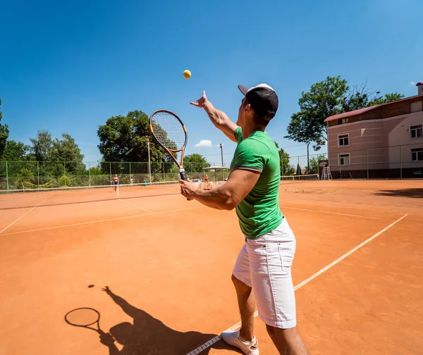 Joven atlético jugando al tenis en la cancha. — Foto de Stock