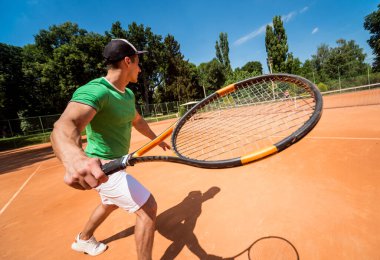 Sahada tenis oynayan genç bir atletik..