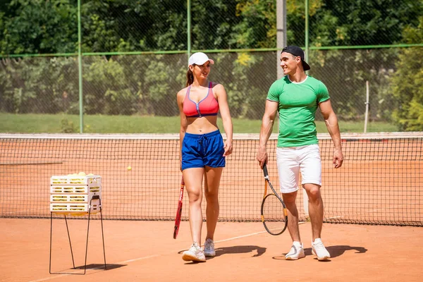 Mladá atletka hraje tenis se svým trenérem. — Stock fotografie