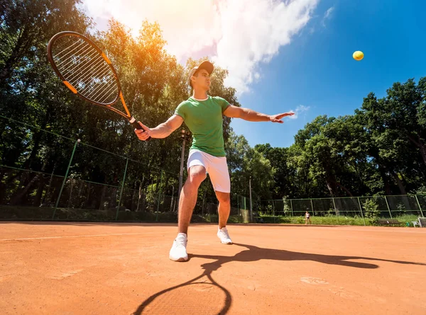 Młody sportowiec gra w tenisa na korcie. — Zdjęcie stockowe