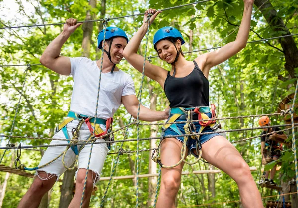 Jovem casal se divertindo no parque de corda de aventura. — Fotografia de Stock